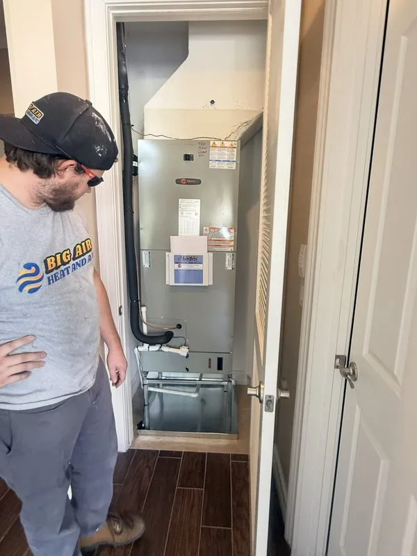 Big Air technician in branded shirt inspecting a Trane air handler installation