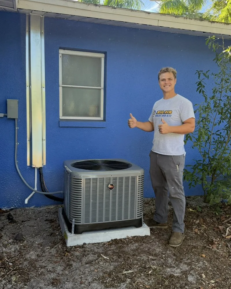 Joseph, owner of Big Air Heat and A/C, giving a thumbs up next to a new AC condenser he installed at a Fort Myers home